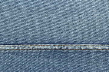 Blue jeans background with horizontal seam line.