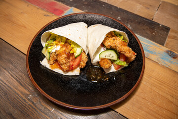 Delicious sizzling chicken fajitas with guacamole and sour cream on a wooden kitchen work top