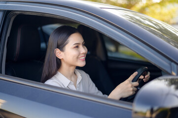 Fototapeta na wymiar Beautiful young smiling woman driving her car, insurance and finance concept
