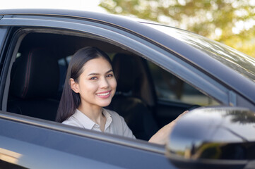 Beautiful young smiling woman driving her car, insurance and finance concept