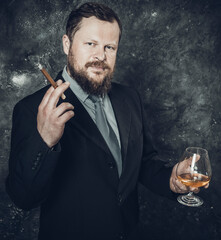 Solid confident bearded man in suit with glass of whisky and cigar