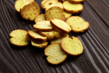 Bruschette chips, dry slices of baked bread, beer snacks scattered on wooden table