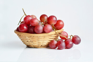 Red grape in an old basket on white background