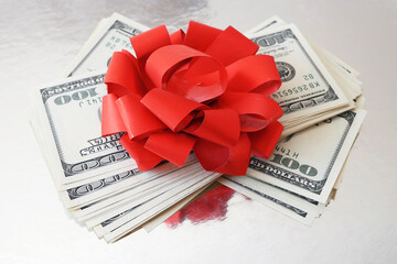 stack of money with bow rotation on silver xmas background, merry christmas, happy new year, wealth...