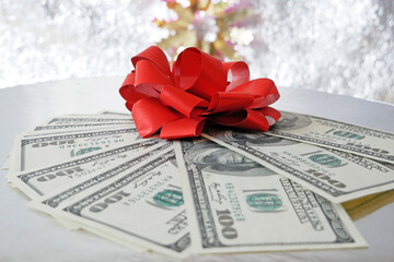 stack of money with bow rotation on silver xmas background, merry christmas, happy new year, wealth...