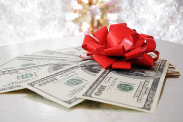 stack of money with bow rotation on silver xmas background, merry christmas, happy new year, wealth...