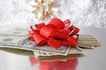 stack of money with bow rotation on silver xmas background, merry christmas, happy new year, wealth...