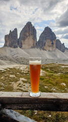 A pint of beer the view on the famous Tre Cime di Lavaredo (Drei Zinnen) in Italian Dolomites. The...