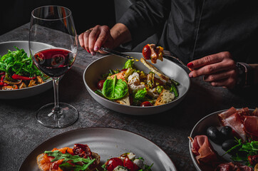 woman eating healthy salad from bowl sitting in cafe