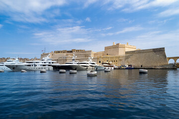 Super Yachts moored in Dockyard Creek in front of Fort St Angelo, Birgu (Vittoriosa), Malta.