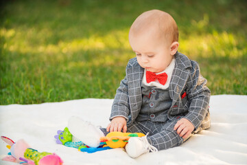 boy sitting on a blanket with toys