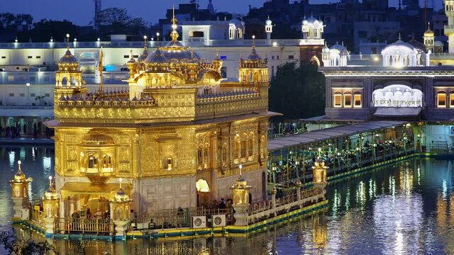 Sikh pilgrims visiting the Golden Temple aka Harmandir Sahib at dusk in Amritsar, Punjab, India. The Golden Temple is the Sikhs' holiest shrine and one of the most important religious sites in India.	