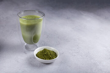 Matcha with milk in a glass on a light background