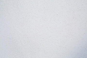 White wall plaster with grey dots. Background picture. Concrete surface panted in light color. Wallpaper textured picture. top view