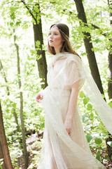 Portrait of a woman in a forest. Space for text. The concept of fashion. Magic fabulously fairytale photo. 
bride in nature