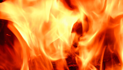 Abstract fire flame in fireplace, texture for background. Beautiful bright orange flames flicker in the darkness of the night.
