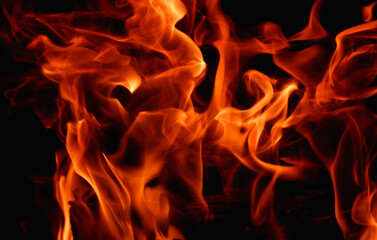 Abstract fire flame in fireplace, texture for background. Beautiful bright orange flames flicker in the darkness of the night.