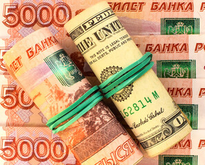 American dollars and Russian rubles rolled up in a tube. Currency exchange rate. Ruble devaluation concept. Money background. Selective focus.