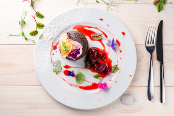 Rich chocolate fondant served with ice cream, fresh strawberries and mint, chocolate fondue with a...