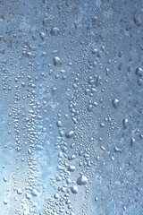 The texture of frozen drops of condensation on a transparent glass window. Water drops. Rain. Abstract texture background. A sharp cold snap, a frozen drop of water on the glass in winter
