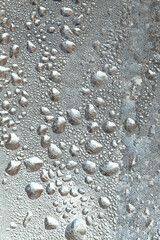 Frozen drops of condensation on a window, a sharp drop in temperature, sharply frozen drops of water on glass in winter, extremely cold low air temperatures