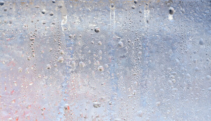 The texture of frozen drops of condensation on a transparent glass window. Water drops. Rain. Abstract texture background. A sharp cold snap, a frozen drop of water on the glass in winter