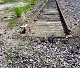 End of the line, railroad tracks end, gravel, dirt, broken glass.