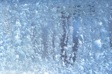 Natural frozen drops of condensation on transparent glass. Beautiful background from a frozen window in winter. Drops texture on the glass