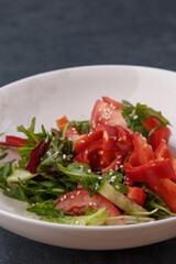 Vegan Spring Salad. Tomato, lettuce, dressing, bell peppers and avocados. Fork with vegetables and salad.