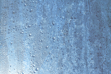 Frozen drops of condensation on a window, a sharp drop in temperature, sharply frozen drops of water on glass in winter, extremely cold low air temperatures