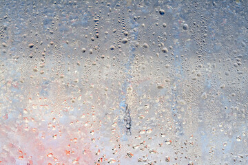 Frozen drops of condensation on a window, a sharp drop in temperature, sharply frozen drops of water on glass in winter, extremely cold low air temperatures