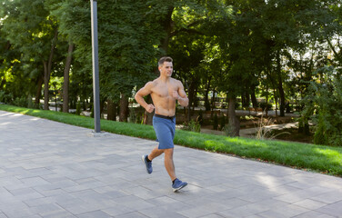 Young athletic man doing jogging outdoors. Cardio workout, healthy lifestyle