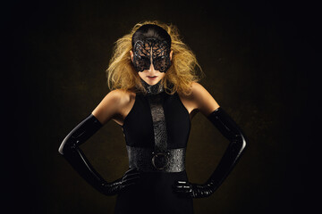 Portrait of a pretty young woman wearing fetish clothes and a lace mask - obrazy, fototapety, plakaty