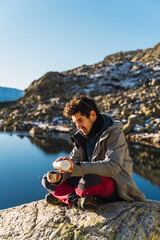 Young boy preparing a hot tea in the mountains after a day of trekking