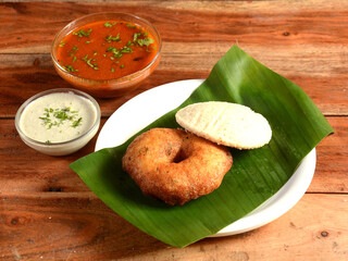 South indian breakfast combination of Medu vada and Idli or idly is a traditional and popular Food served with bowls of chutney and sambar as side dishes.selective focus