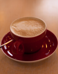 red cup of cappuccino on the table
