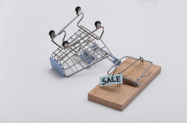 Mousetrap with sale bait and shopping trolley on white background. Trap or deception concept