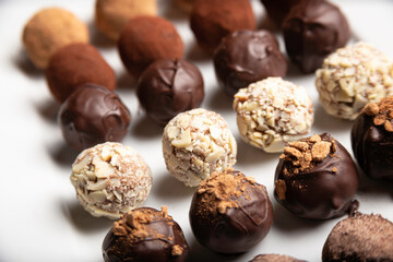 variety of handmade gourmet chocolate truffle candy on a white plate