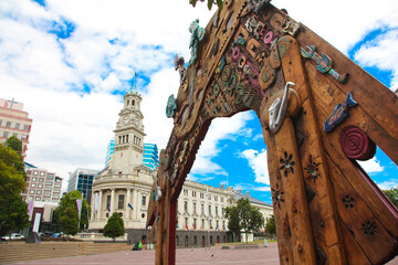 Waharoa gate inspired by Maori and Polynesian influences in Aotea Square, with Auckland Town Hall in the background. The Town Hall is a Edwardian building, Queen Street, Auckland CBD, New Zealand. - obrazy, fototapety, plakaty