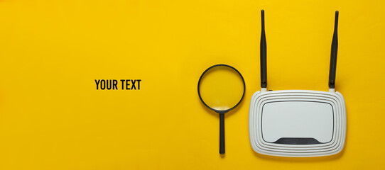 Search on the Internet. Wifi router and magnifier on yellow paper background with space for your text. Top view