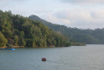 Fototapeta na wymiar boat on the lake with hills on the background