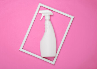 Bottle of spray for washing windows on pink background with a white frame. Top view. Minimalism