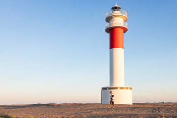 Mother and son walking near a beautiful lighthouse
