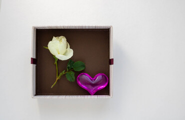 Gift brown box with a heart and a white rose. Concept of Valentine's Day, anniversary, mother's Day and birthday greetings, copyspace, topview