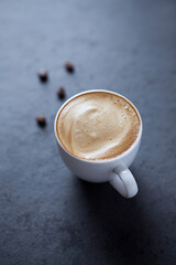 Cup of coffee on dark stone background. Close up.