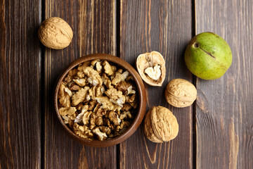 Fototapeta premium Walnuts in round bowl on wooden table