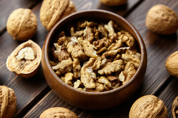 Walnut half and seeds and bowl on wooden table