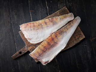 Fresh pikeperch fillet on a wooden cutting board. Top view. 