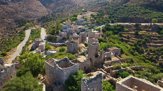Aerial drone video of abandoned old stone tower village of Vatheia overlooking deep blue sea in Mani Peninsula, Peloponnese, Greece