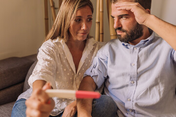 Unwanted pregnancy, contraception fail, safe concept. Frustrated couple checking a pregnancy test